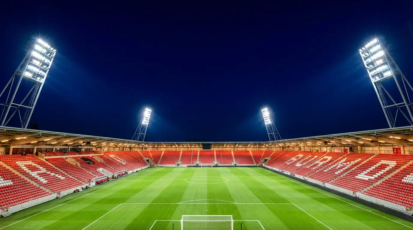 Beleuchtetes Fussballstadion bei Nacht mit WM-Spielfeld